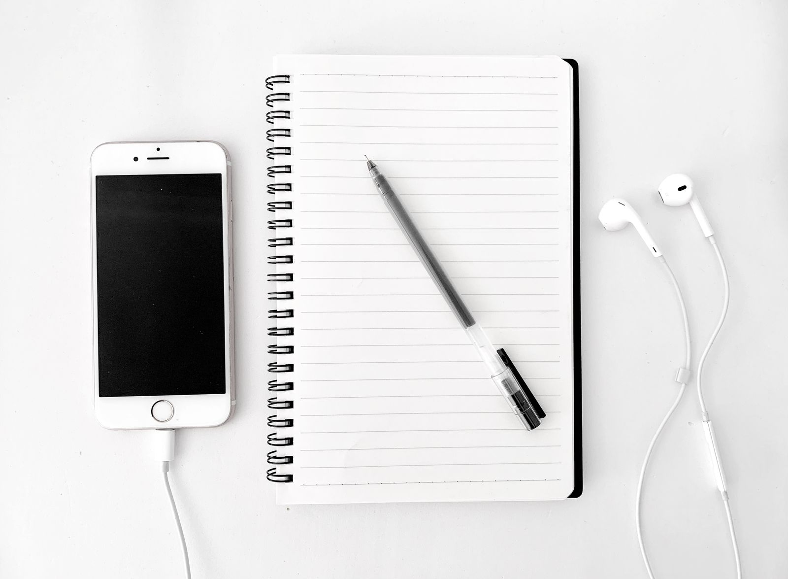 Notebook with pen next to a smartphone